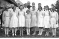 Slávnosť prvého svätého prijímania - dôstojný pán Šátek, dievčatá odeté v bielom, do kostola sa v sprievode nosil veniec (nie je na zábere).  Cca rok 1950